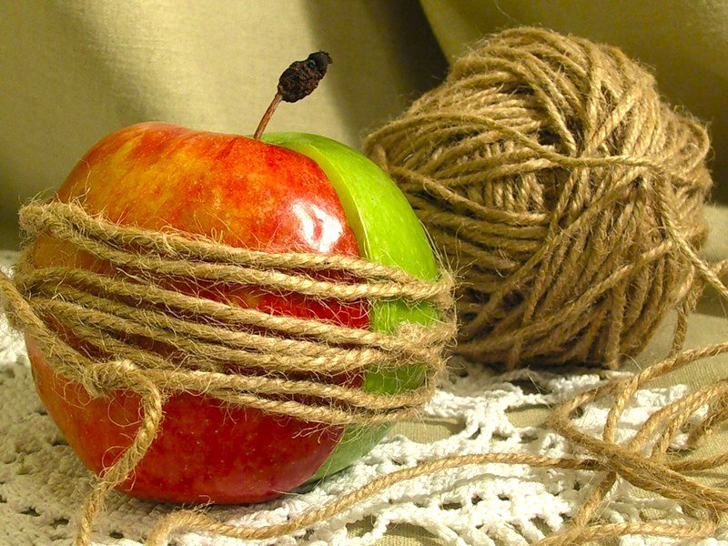 Две половинки яблока, лежащие рядом и соединённые между собой верёвочкой — символ поиска близости, соединения душ и пережитых вместе изменений.